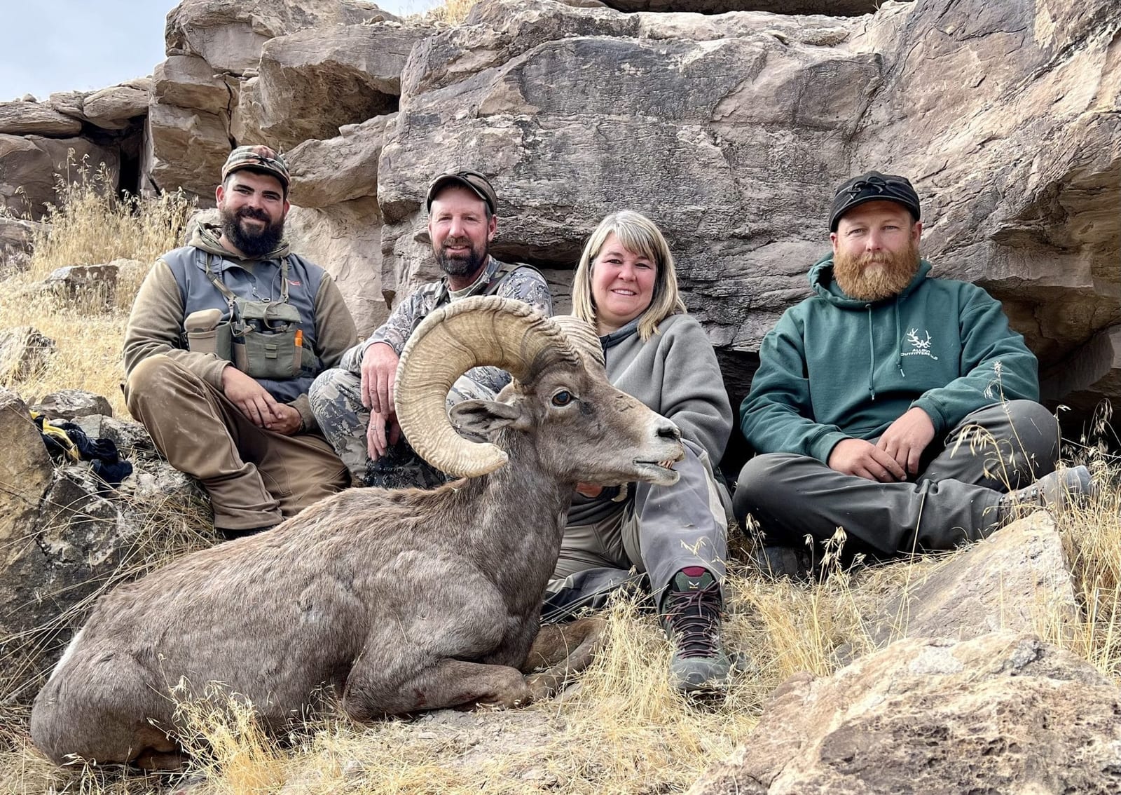 Four hunters pose with a harvested desert bighorn sheep.