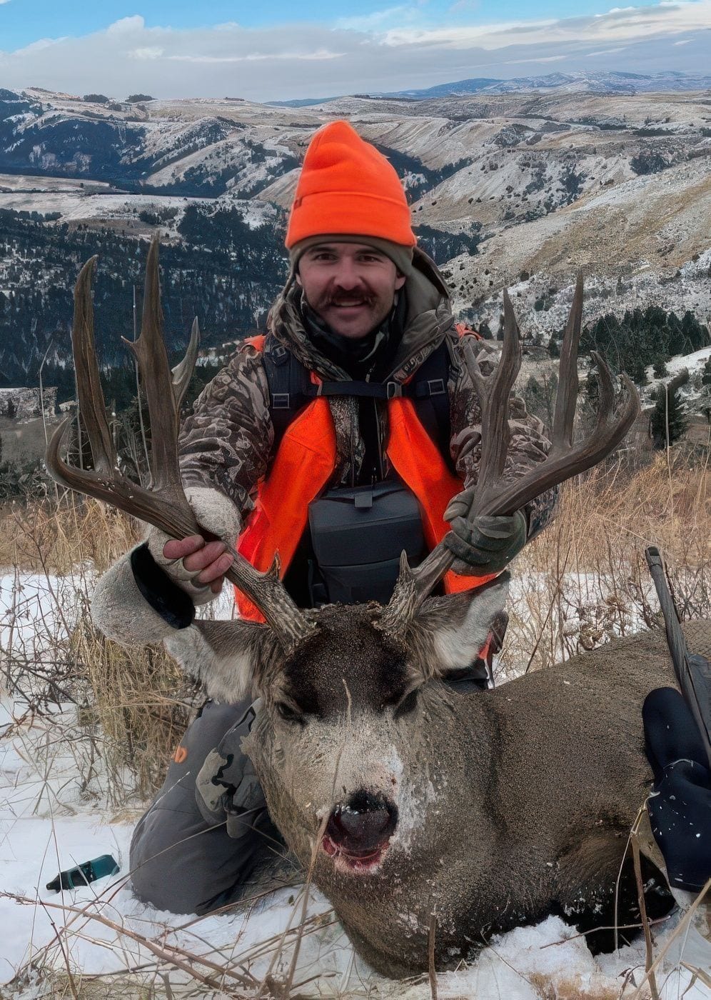 A man holding a big deer.