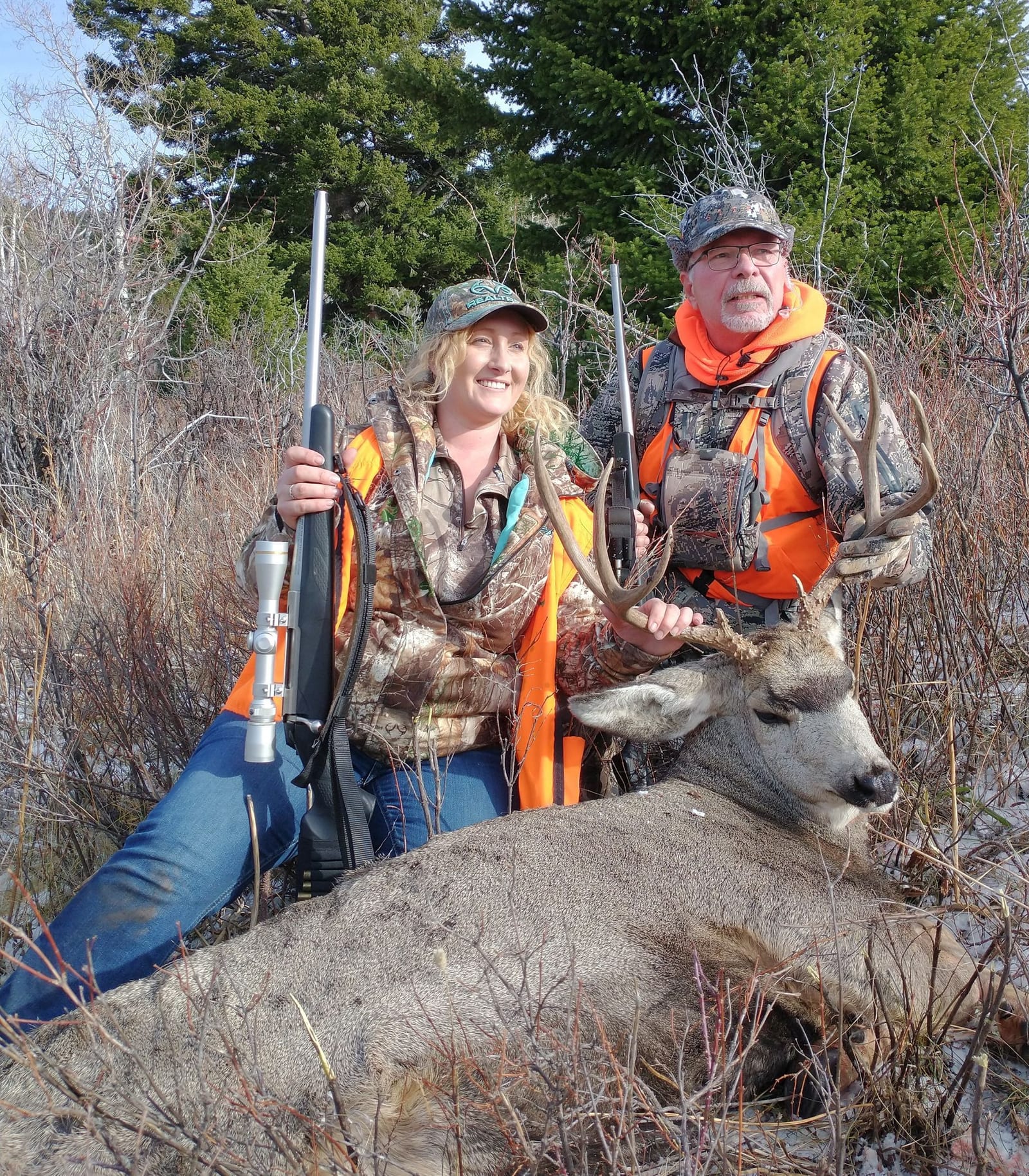 A man and a woman holding a big deer.
