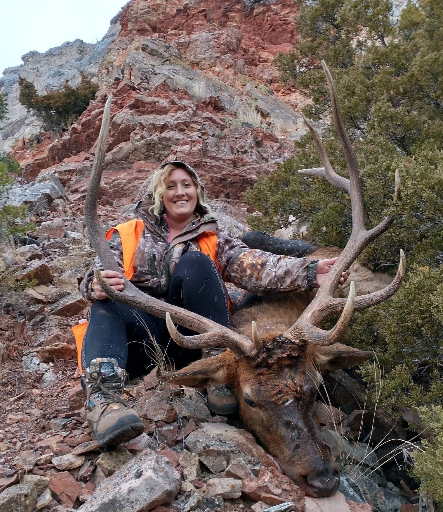 A woman holding a big elk.