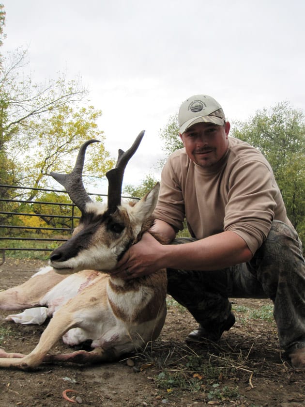 A hunter poses with a harvested pronghorn.