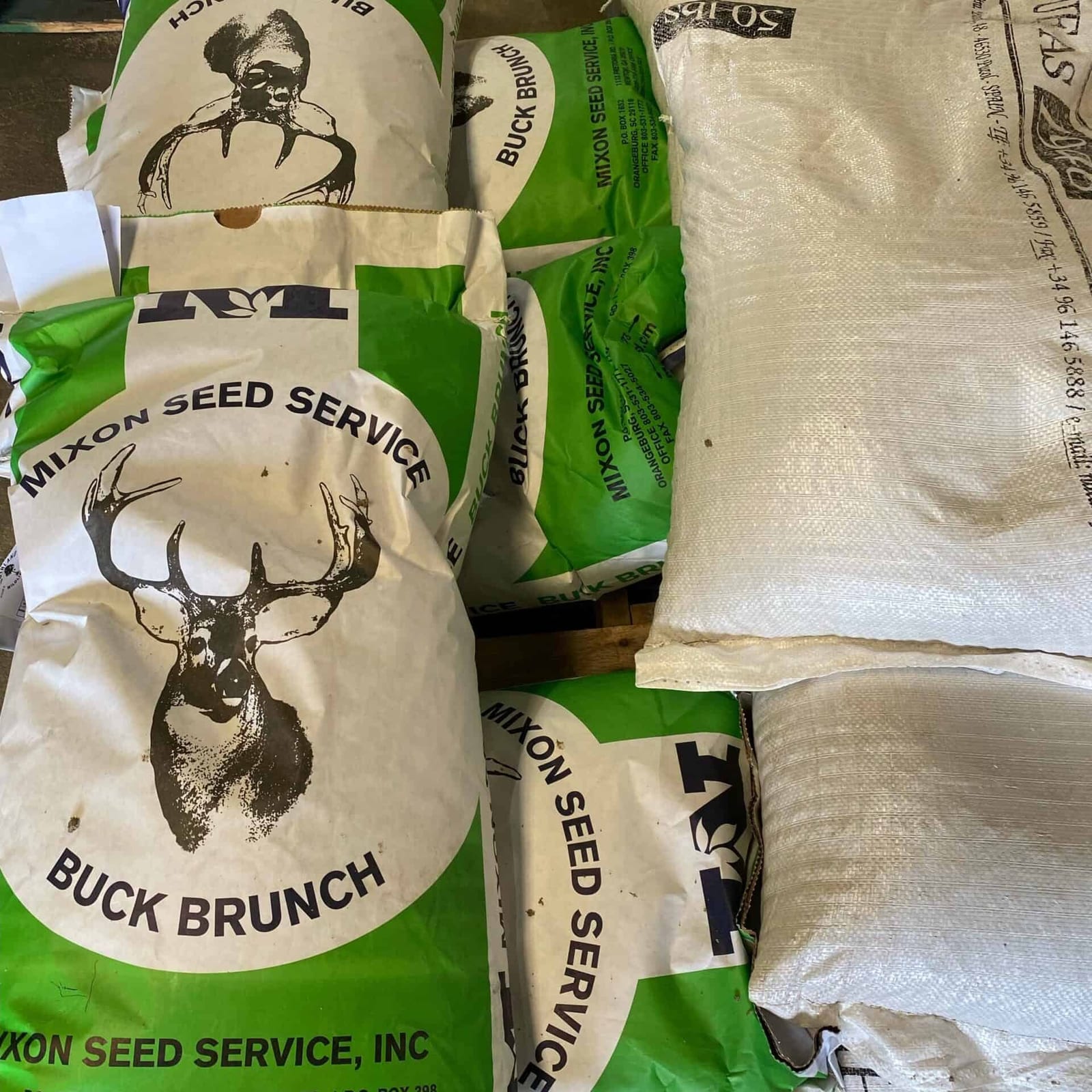 Bags of Mixon Seed Service 'Buck Brunch' deer feed are stacked.