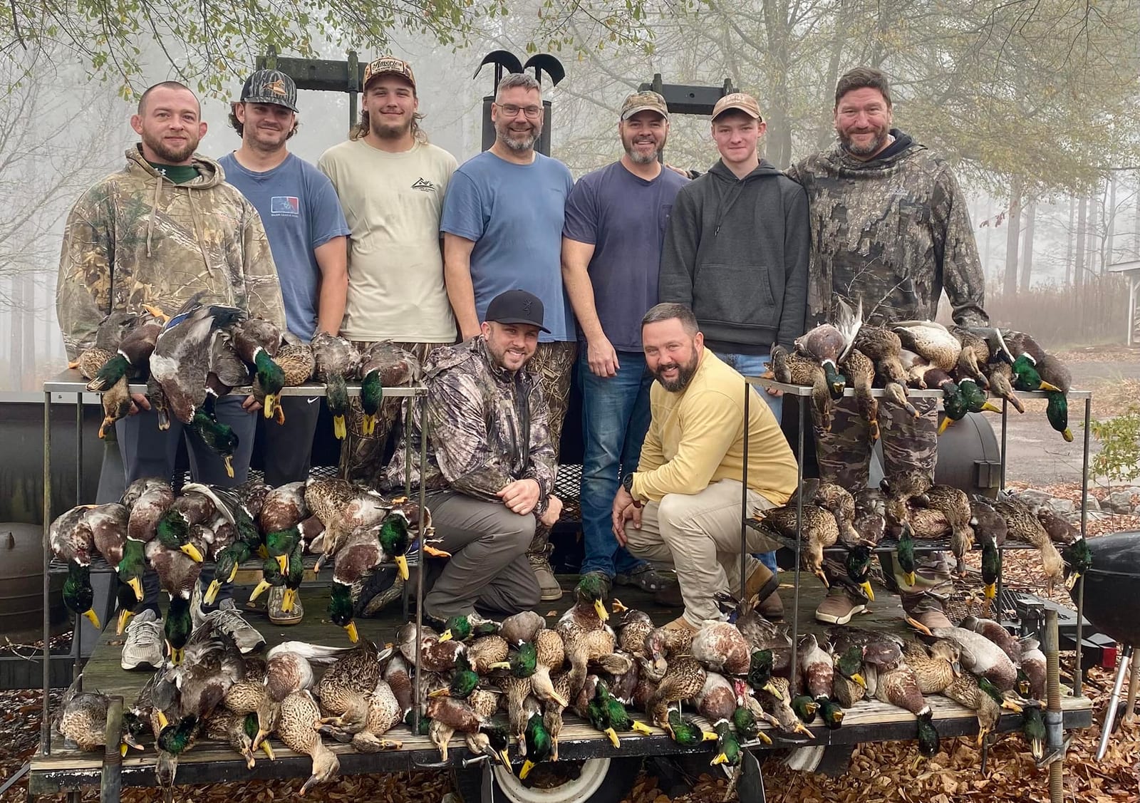 A group of hunters poses with their harvested mallard ducks.