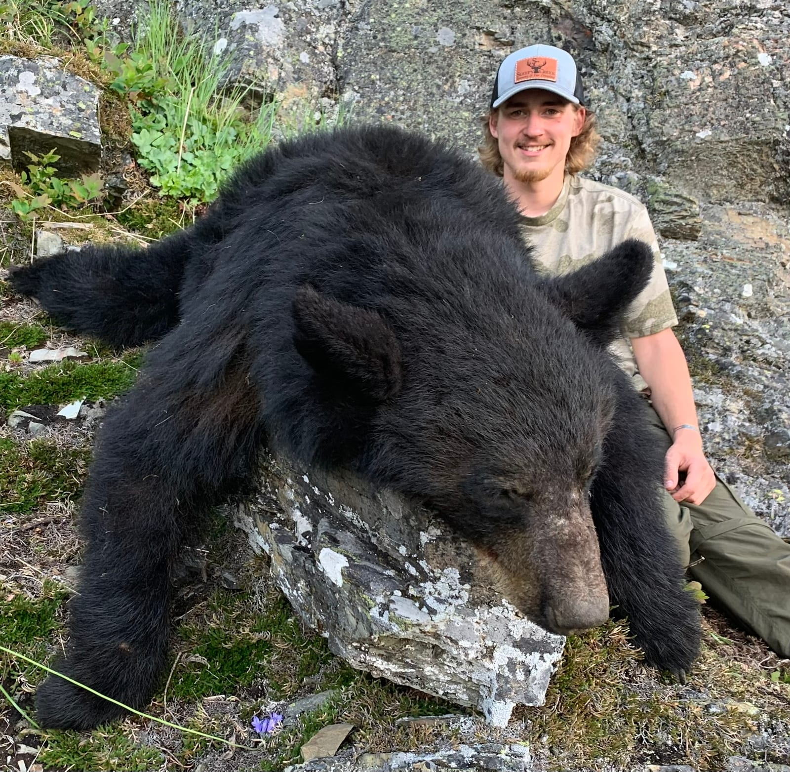 A hunter poses with a harvested black bear.