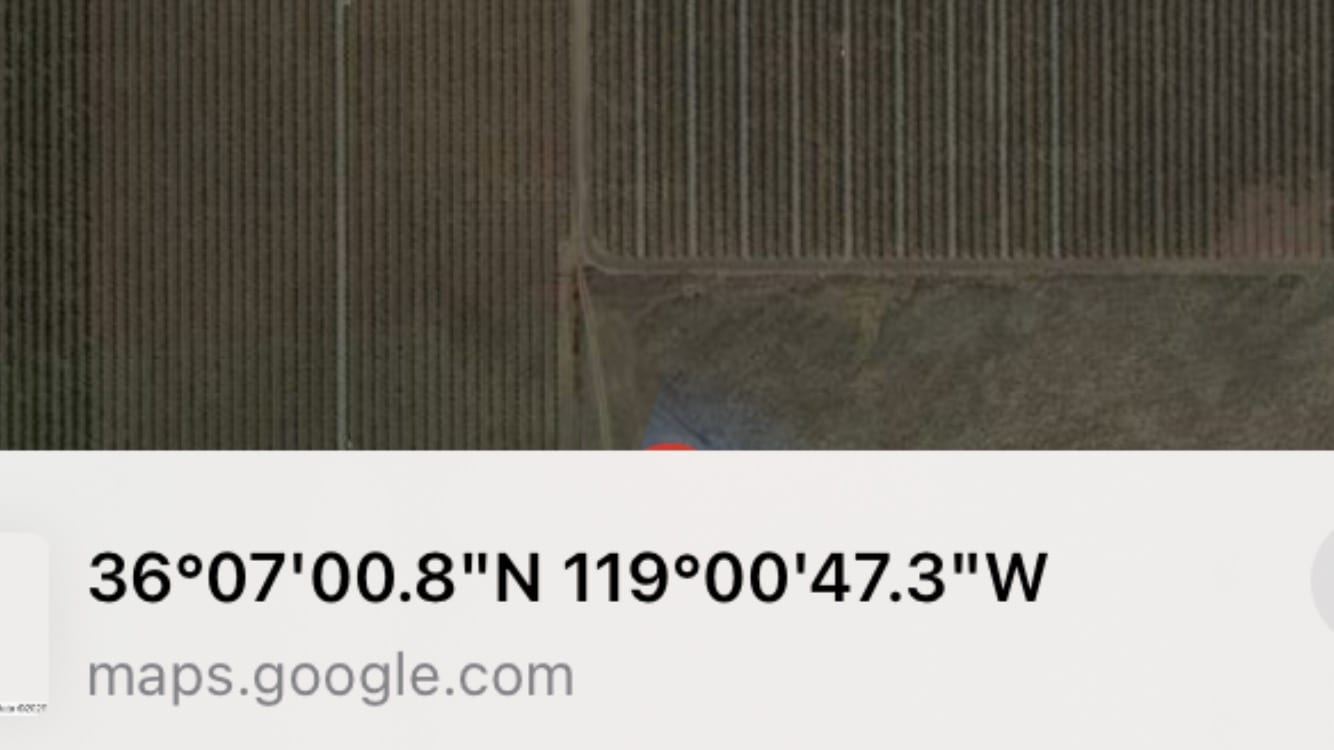 An aerial map view showing agricultural fields with geographic coordinates.