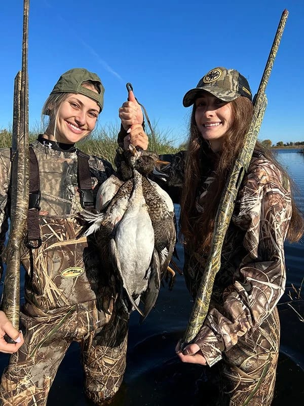 Two girls holding ducks in Northern California on waterfowl hunting trip