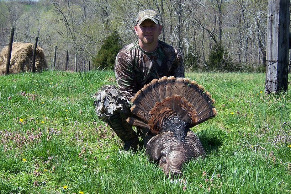 A man poses with his turkey at Long Creek Outfitters