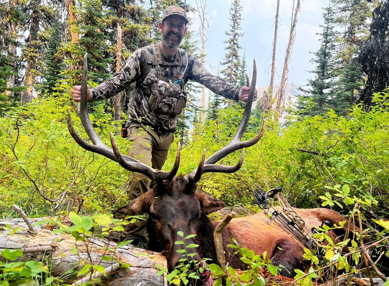 man holding antlers of elk