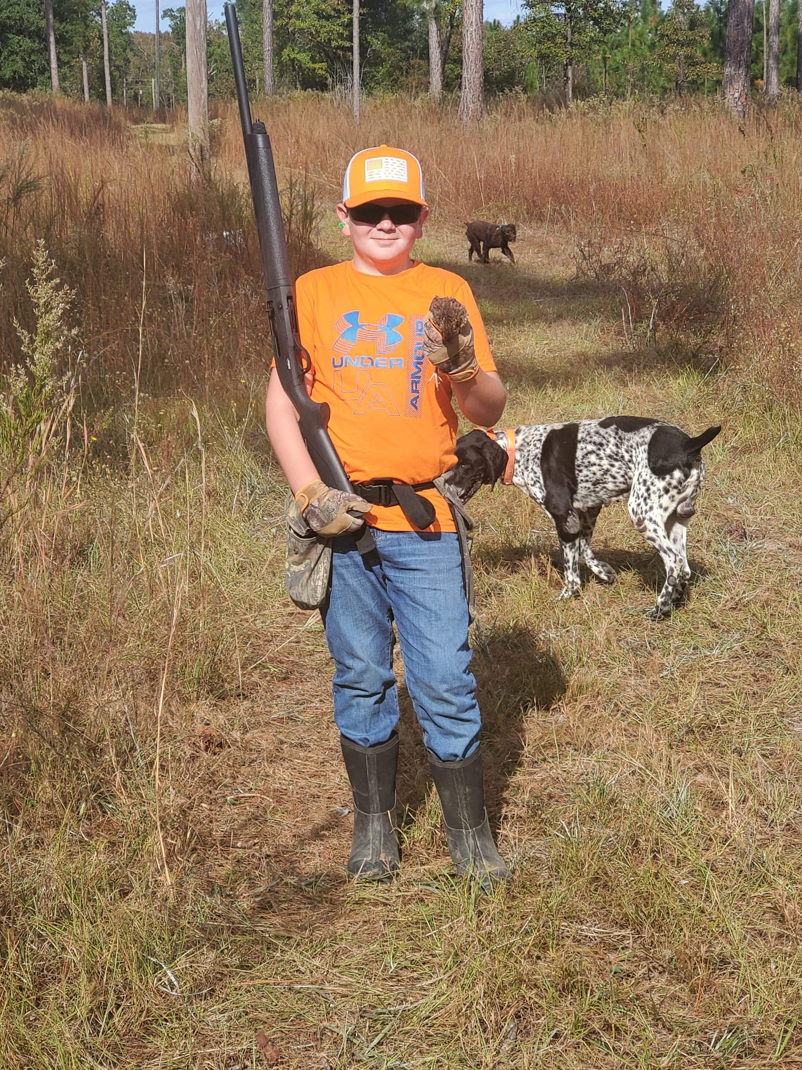 Proud young boy after a successful quail hunt with bird dog