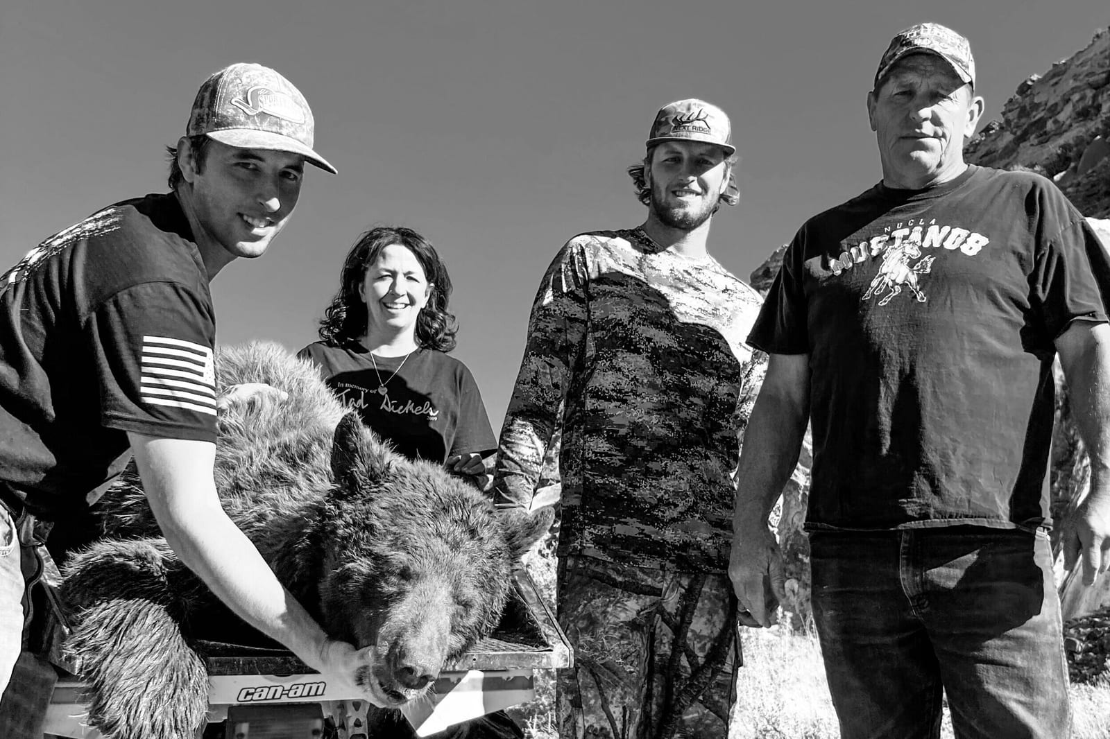 Four hunters pose with a harvested black bear.
