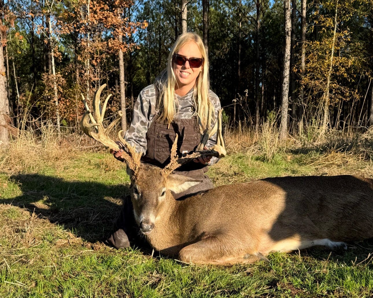 Person with a large deer in a forest setting