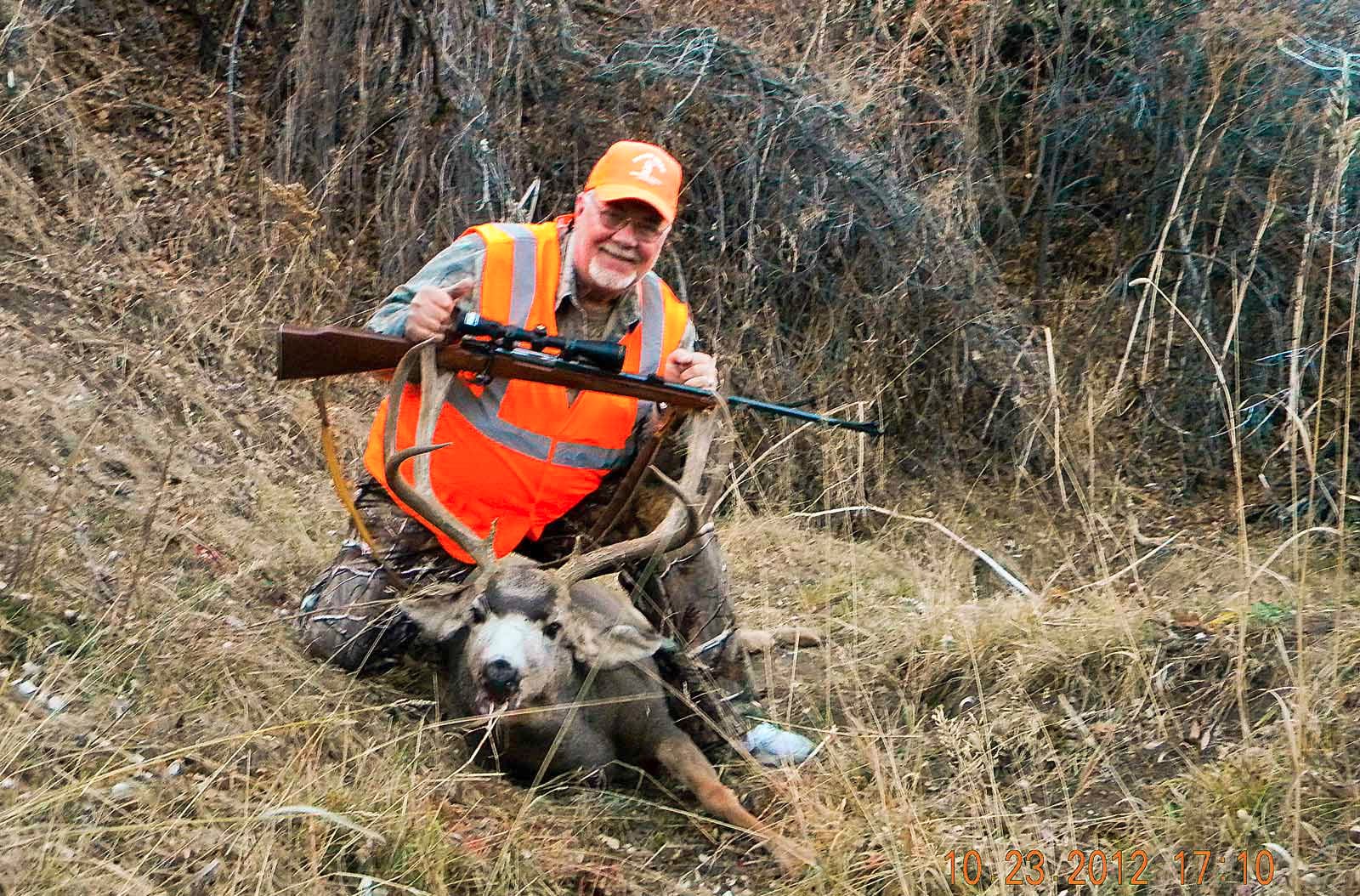A happy hunter with a nice mule deer buck