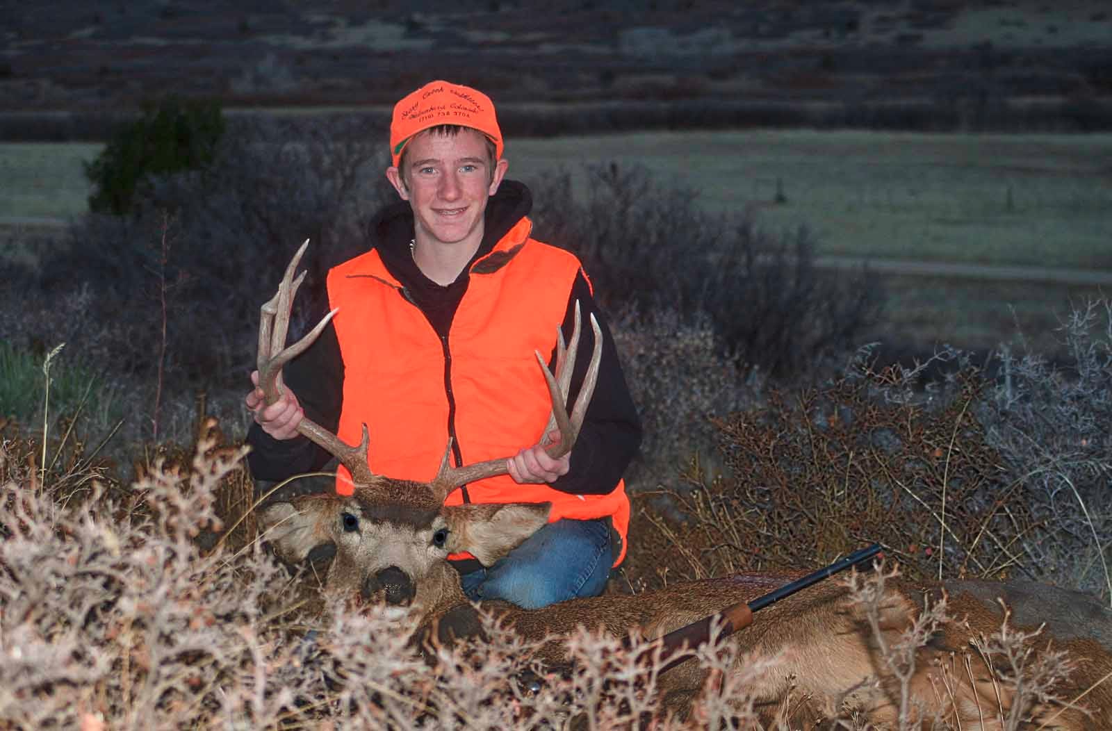 Young man with his mule deer buck