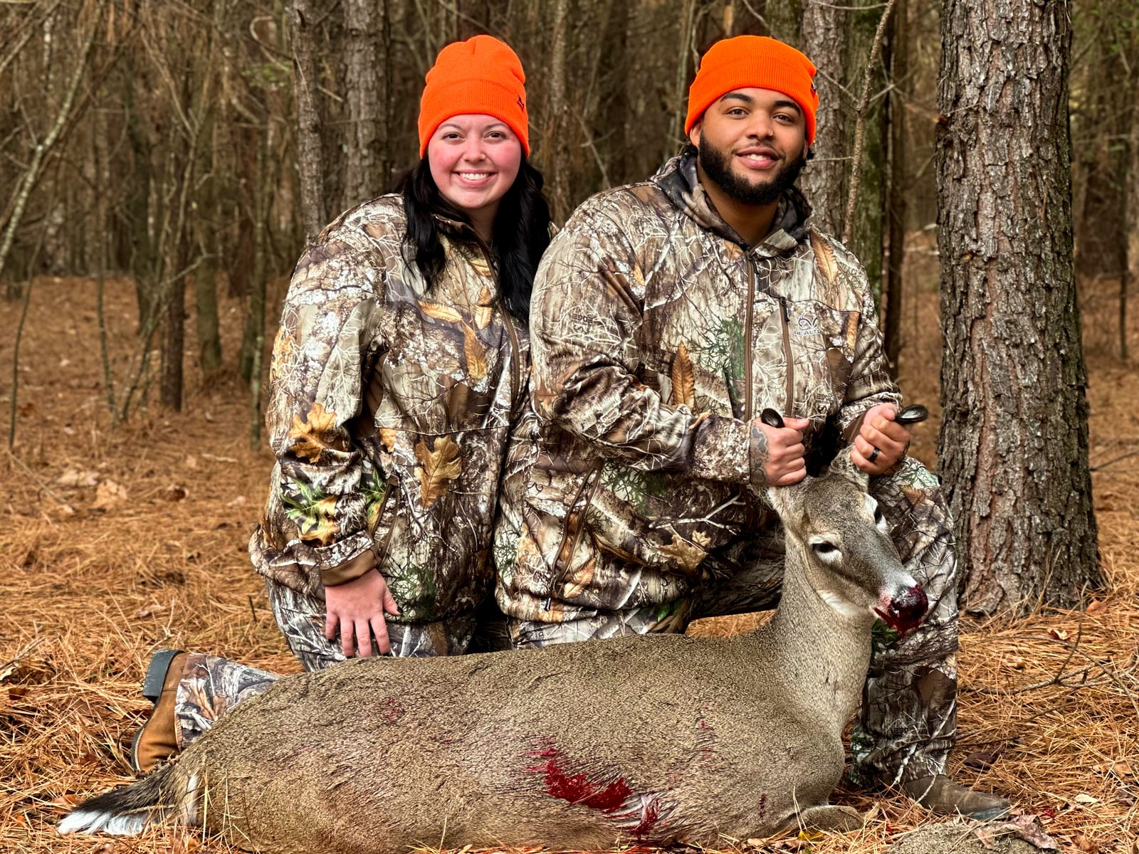 Two happy hunters with their harvested Whitetail deer at Triple Hollow Hunting Preserve, the go-to destination for deer hunts near Altoona, Alabama.