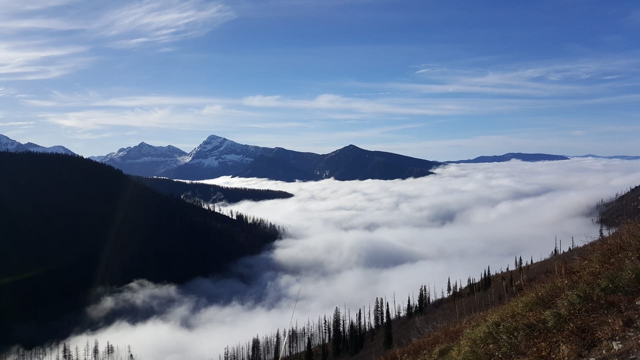 A mountain landscape with clouds filling the valleys and peaks rising above.